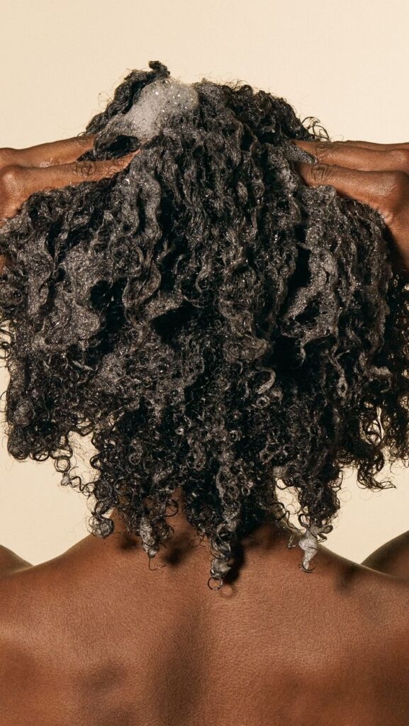 a lady washing her Afro Hair scalp