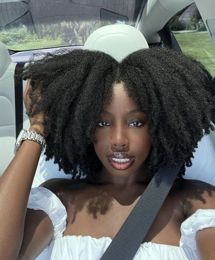 a girl in a car with afro hair