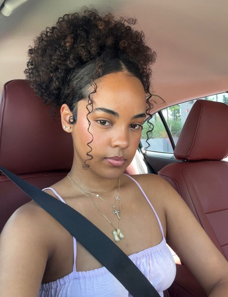 a girl with curly hair inside a car