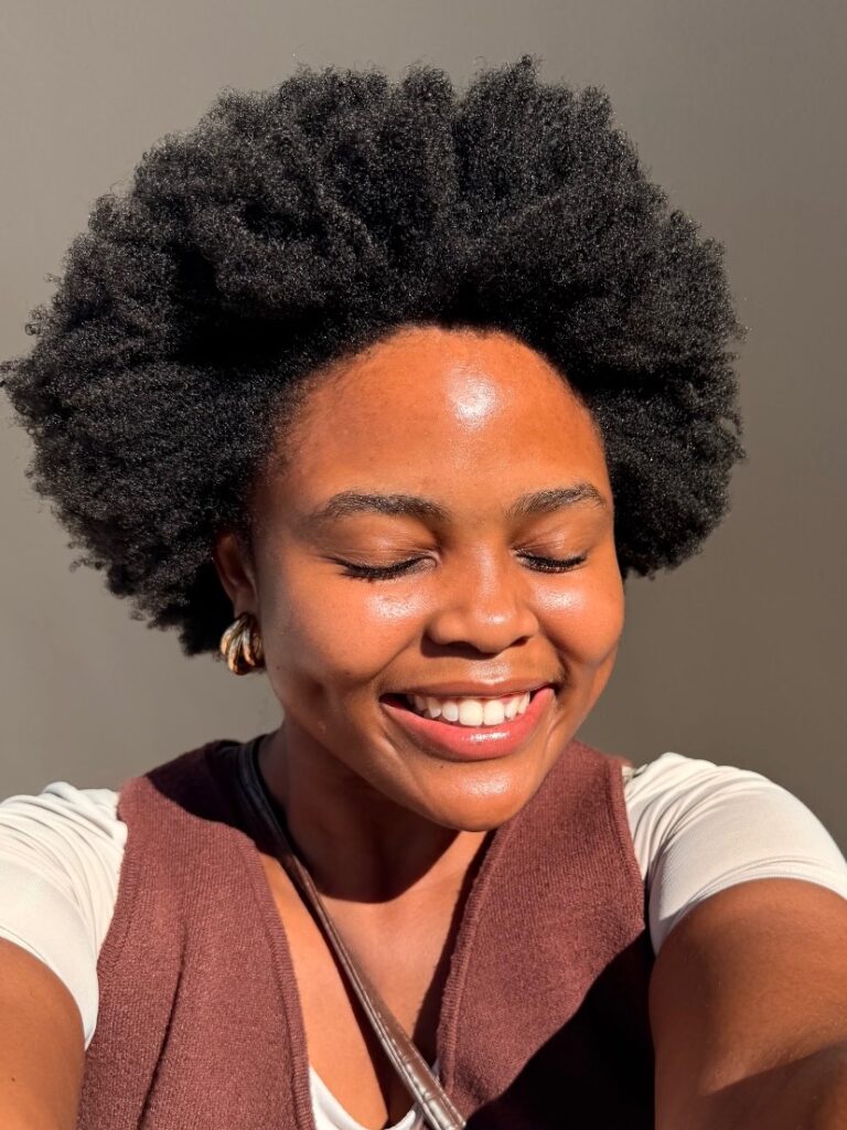 a smiling lady with afro hair