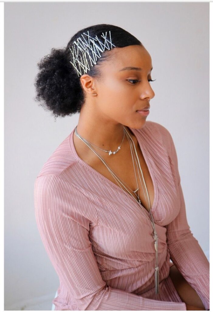 a girl with accessorized afro puff style