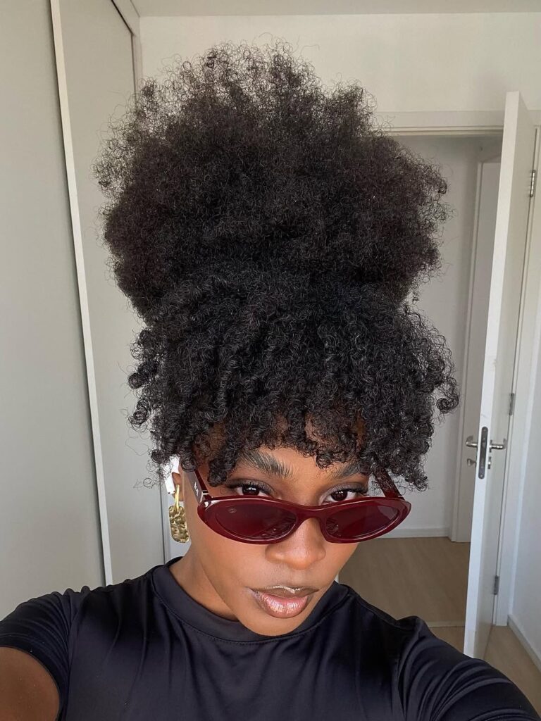 a lady with afro hairstyle name afro puff with small section of hair in the front