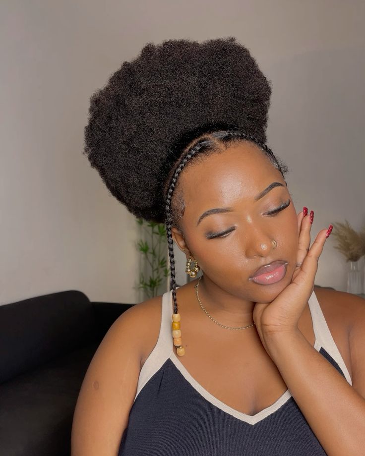 a lady with a beautiful afro hairstyle called afro puff with two flat twists in the front