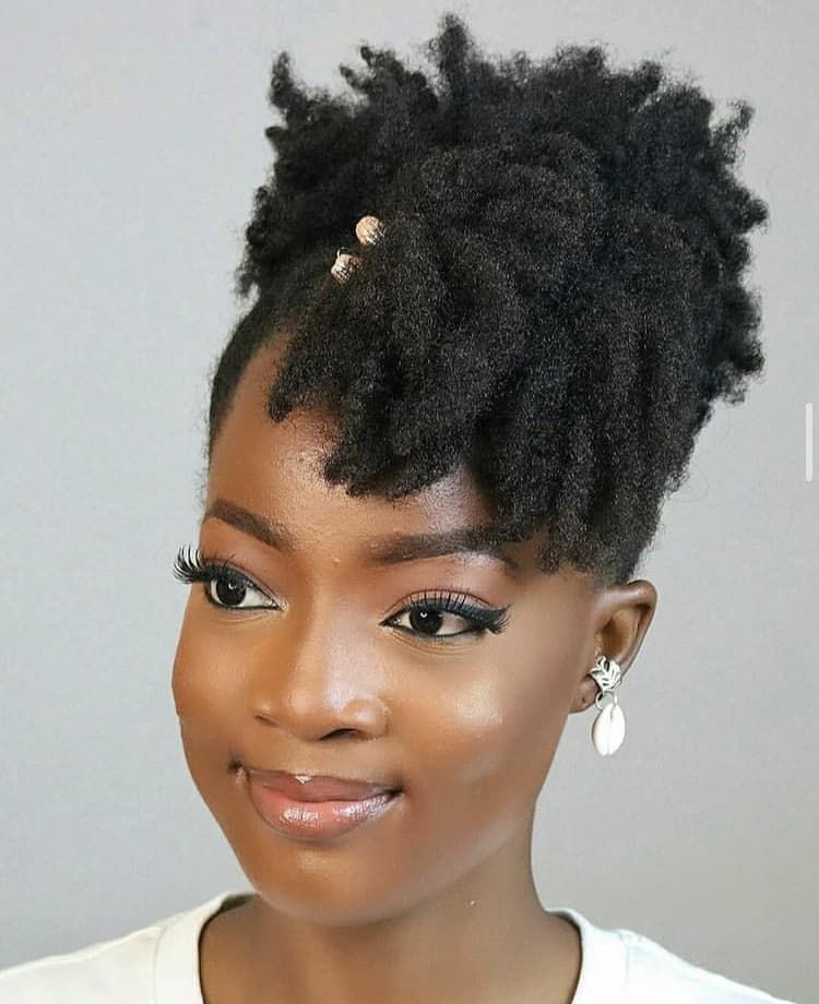 a girl with asymmetric afro puff style