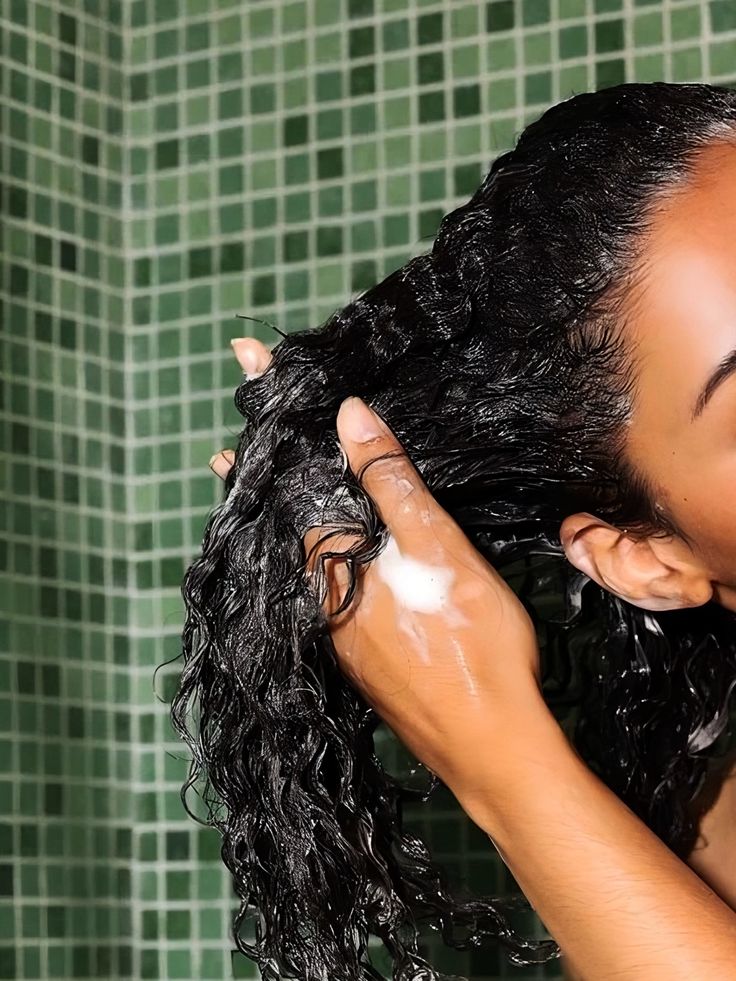 a lady washing her hair in a bathroom