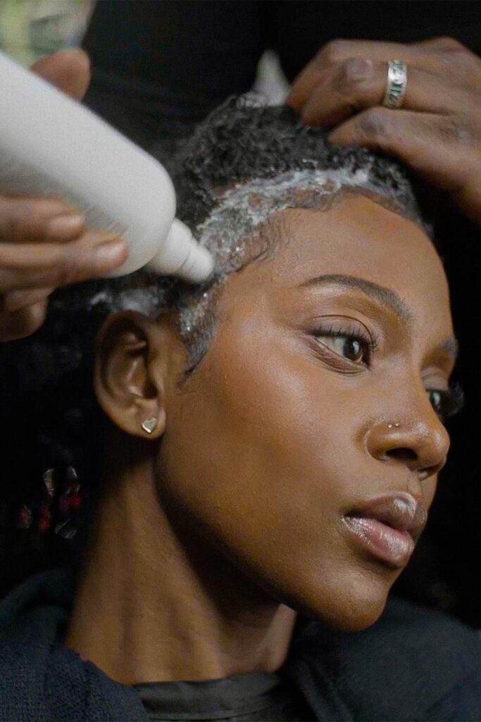 someone cleaning her scalp as part of healthy scalp habit