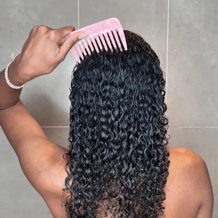 someone combing her curly hair