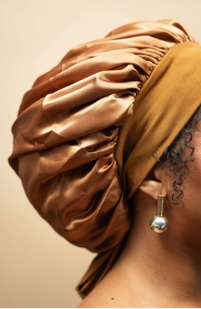 someone covering her hair with satin hair bonnet