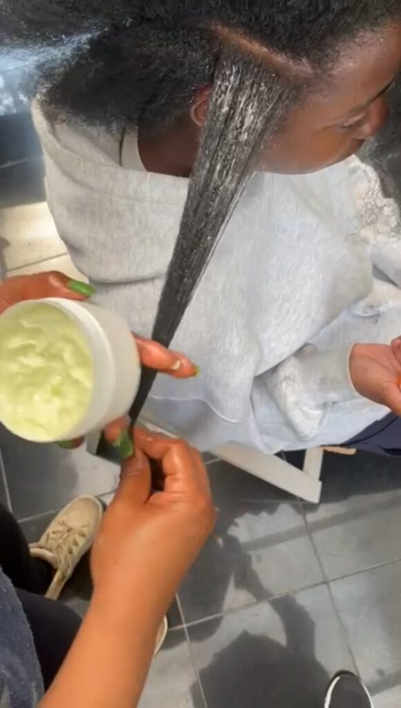 someone applying hair butter to her hair