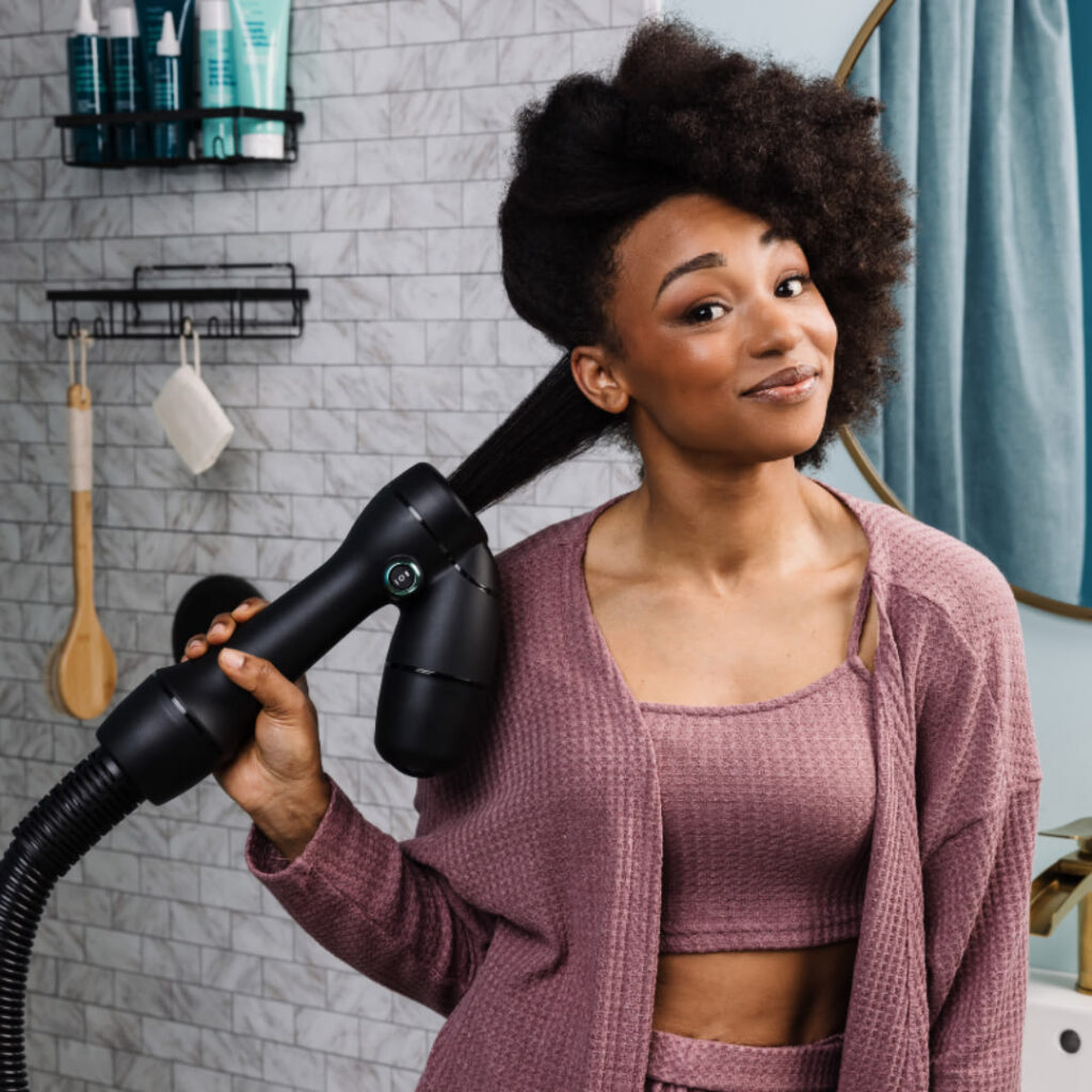 someone drying her hair with hair dryer