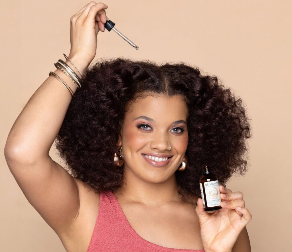 someone applying oil to her hair