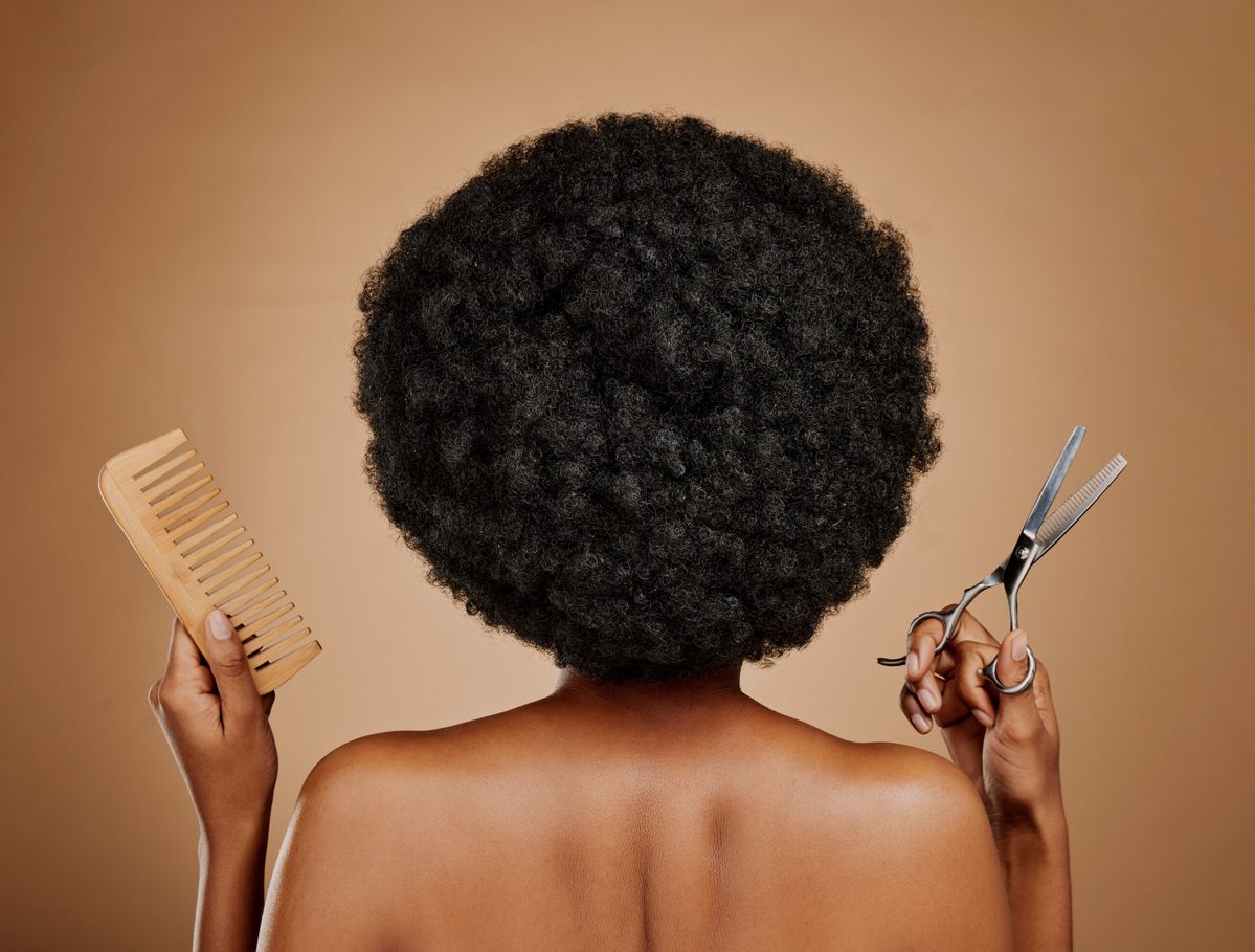 a lady holding a scissors and comb