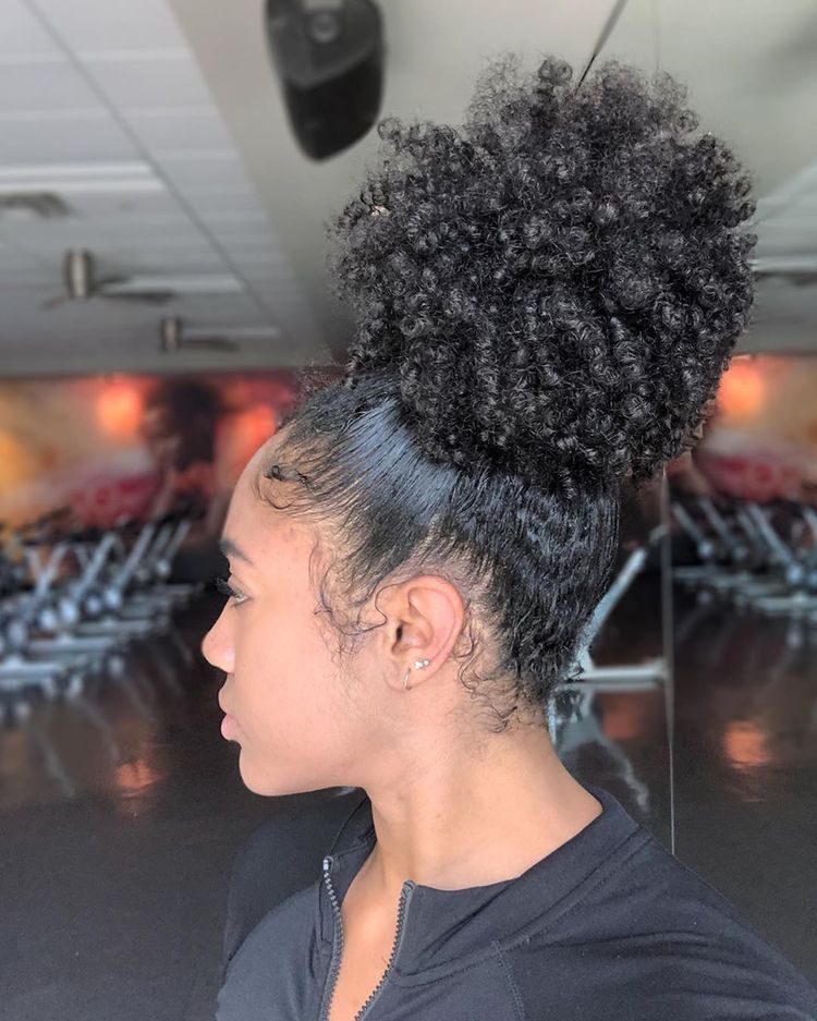 Girl wearing a high puff with defined natural curls.