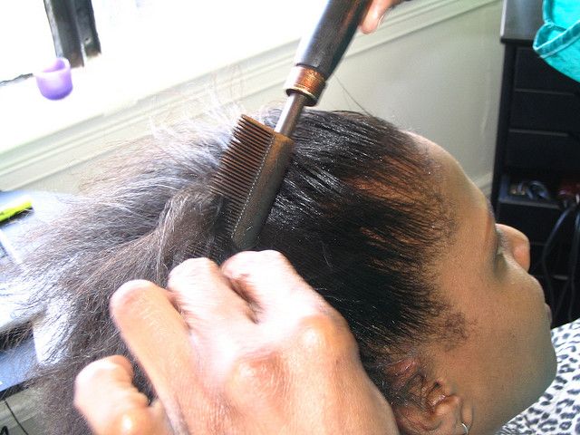 someone hot combing her hair