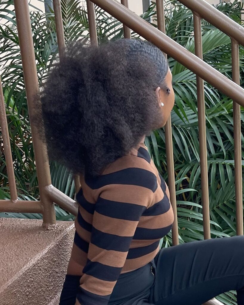 a girl with low afro puff style