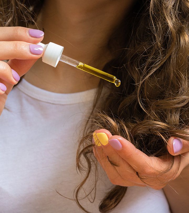 someone applying hair growth oil to her hair