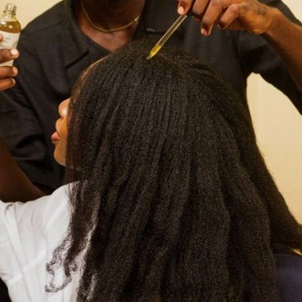 someone oiling her low hair porosity