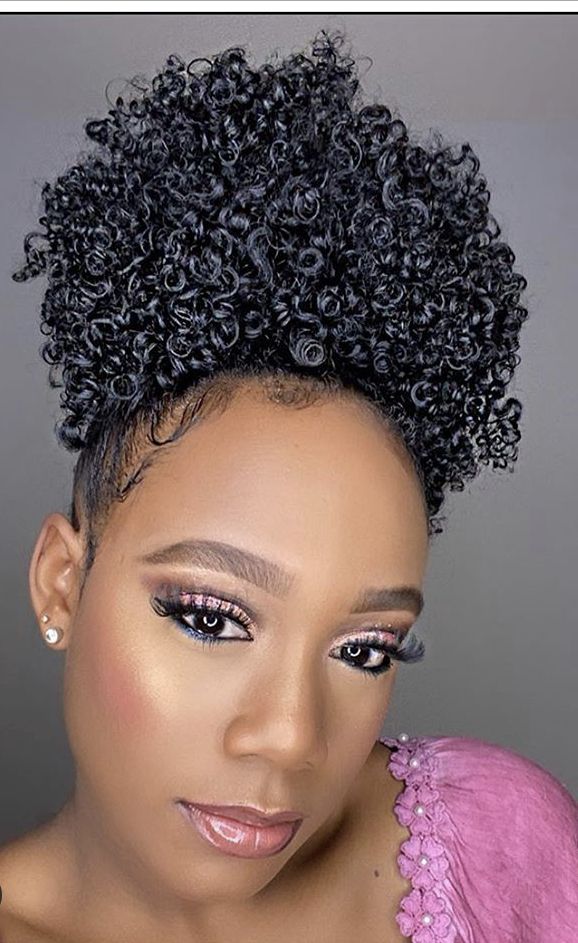 Girl wearing a pineapple hairstyle to preserve defined curls overnight.