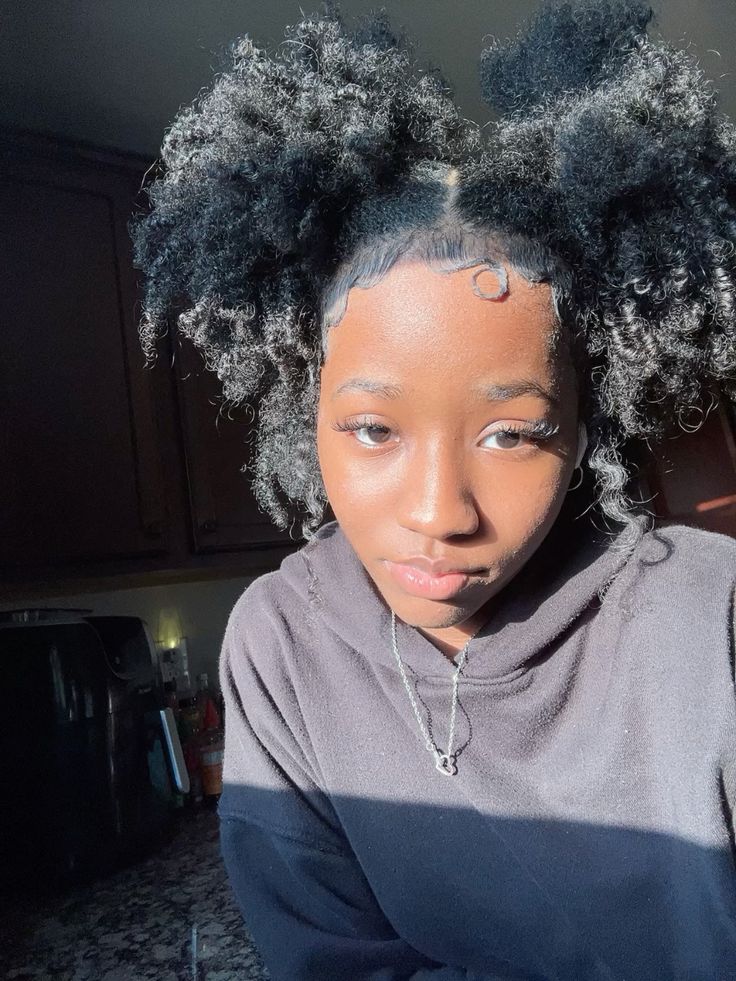 a girl with puff with space buns afro puff style
