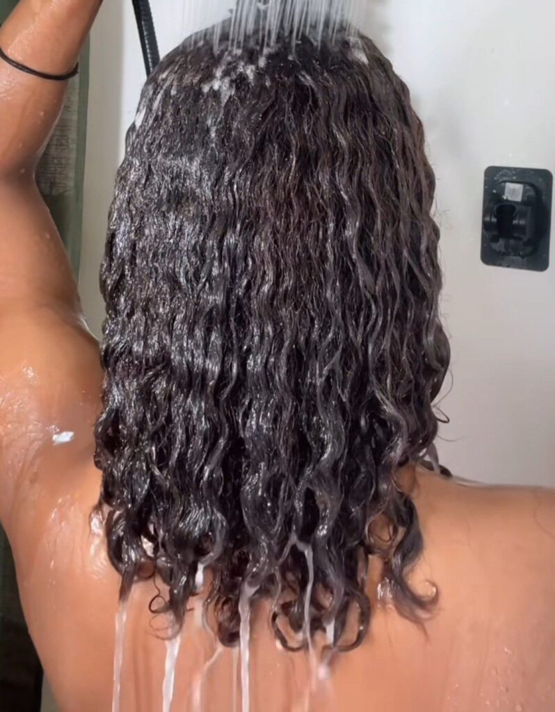 a lady rinsing her hair after wash