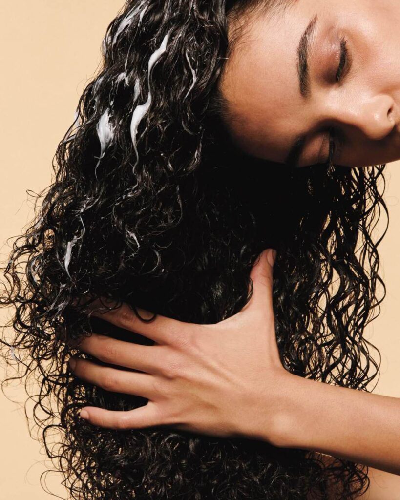 someone rubbing hair cream on her hair