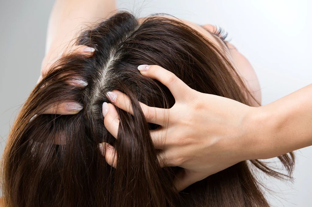 someone massaging her scalp as part of her healthy scalp habit