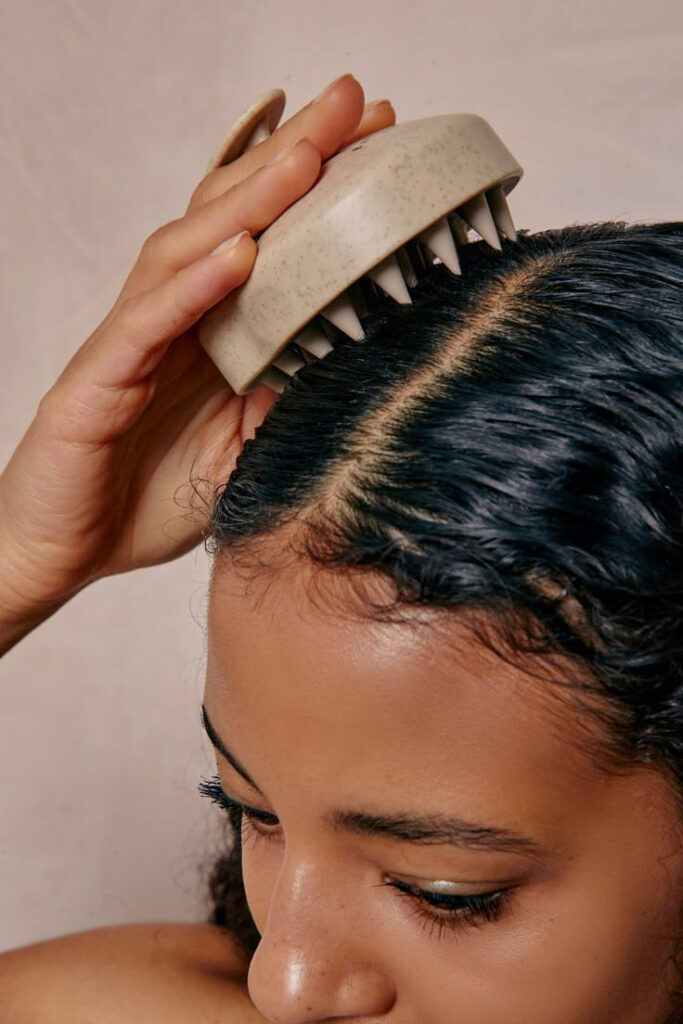 someone massaging her scalp with scalp massaging tool