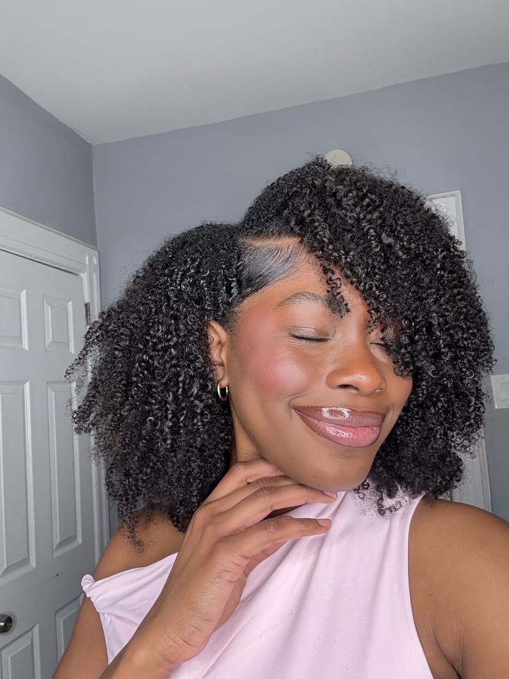 Girl with a side-parted natural curly hairstyle.