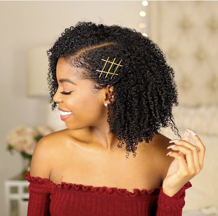 Side-pinned natural curly hairstyle for Afro hair.