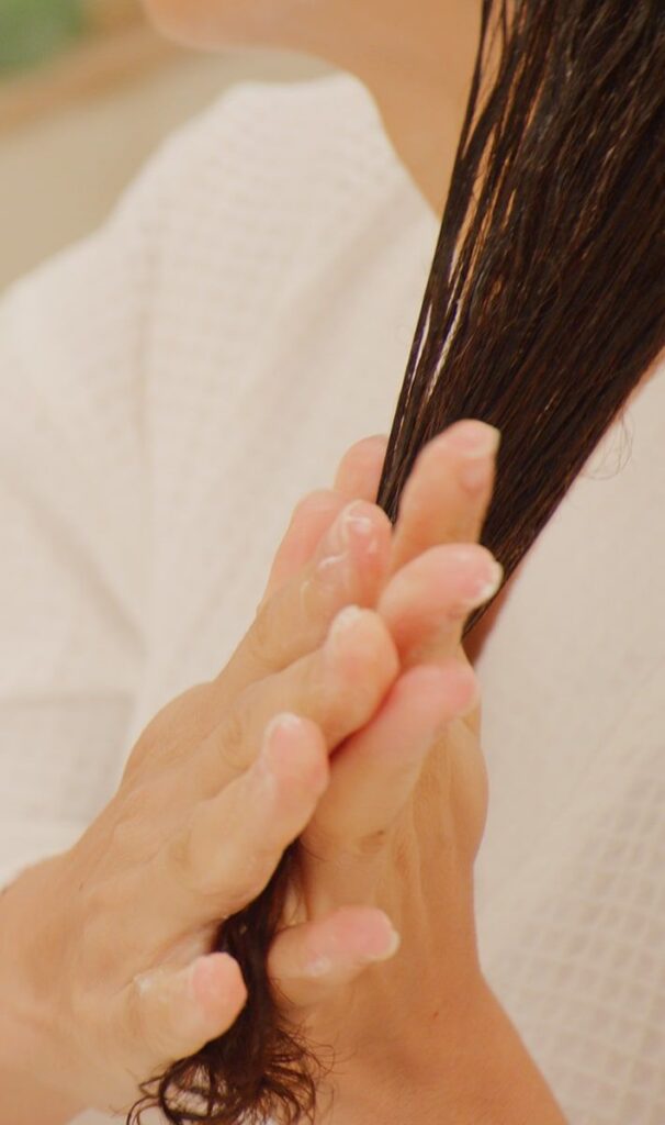 someone applying hair cream to the hair
