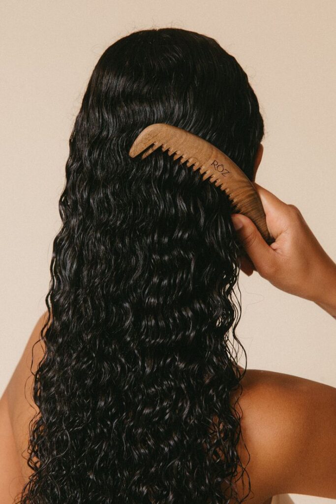 someone combing her curly hair