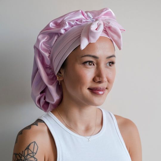 someone covering her hair with satin bonnet