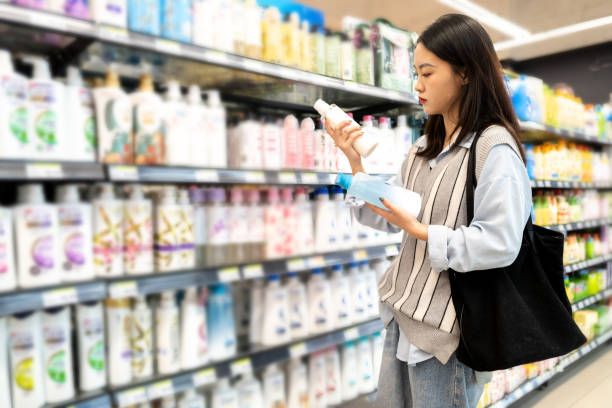 someone reading label of conditioner in the supermarket before buying it