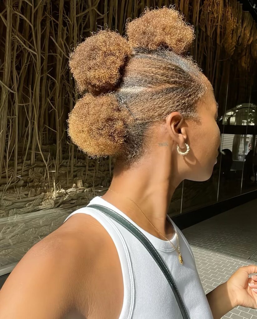 a girl with triple afro puffs style