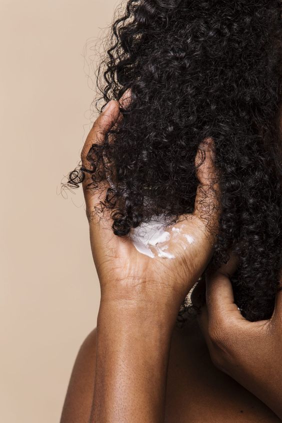 someone using cream on dry hair
