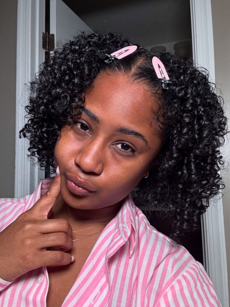 Girl decorating her natural curls with stylish hair clips.