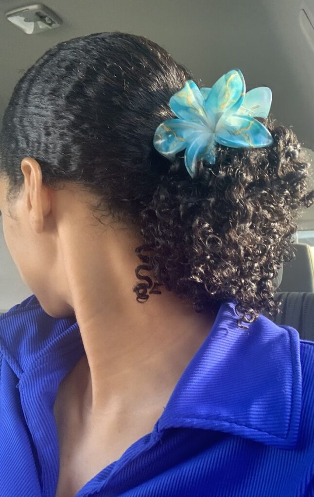 Girl wearing a flower clip with one of the cutest wash and go hairstyles.