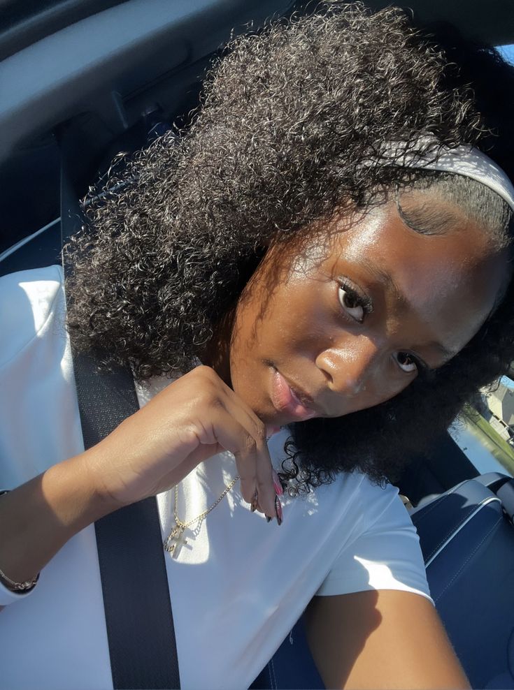 Girl wearing a headband with a defined natural curly hairstyle.
