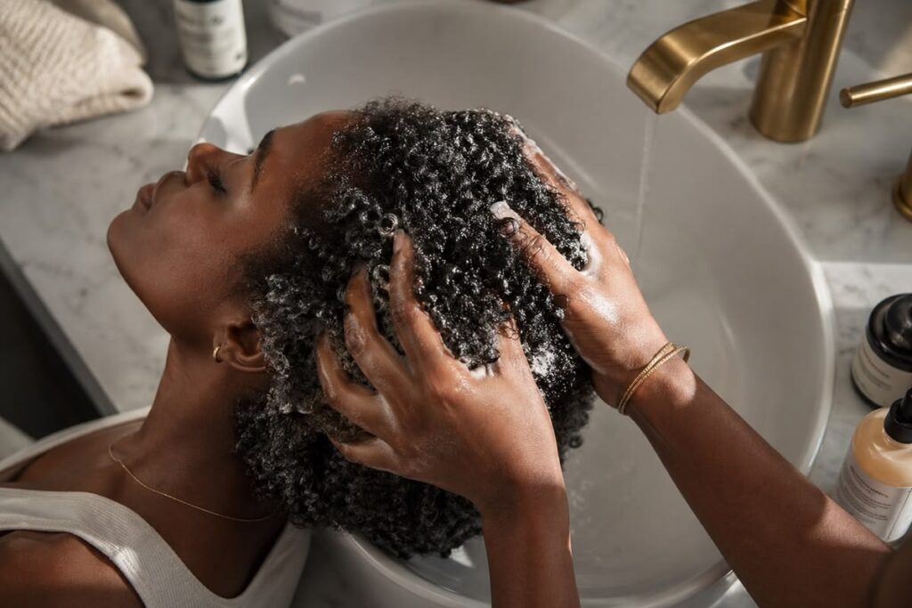 someone getting her hair washed to build healthy afro hair