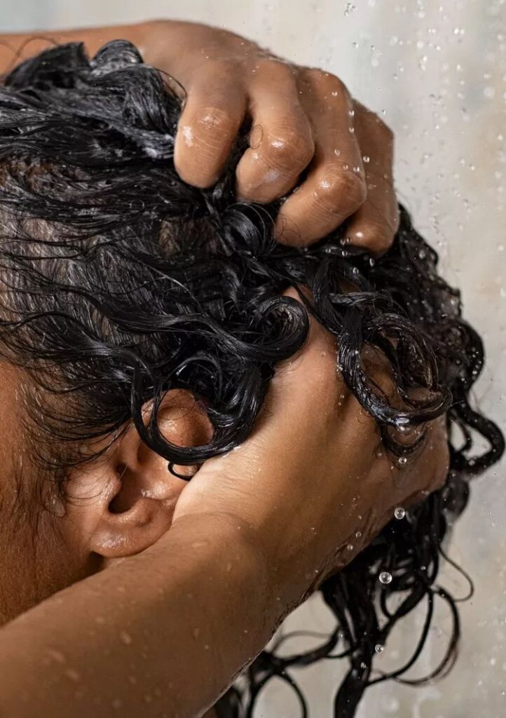 someone washing her curly hair