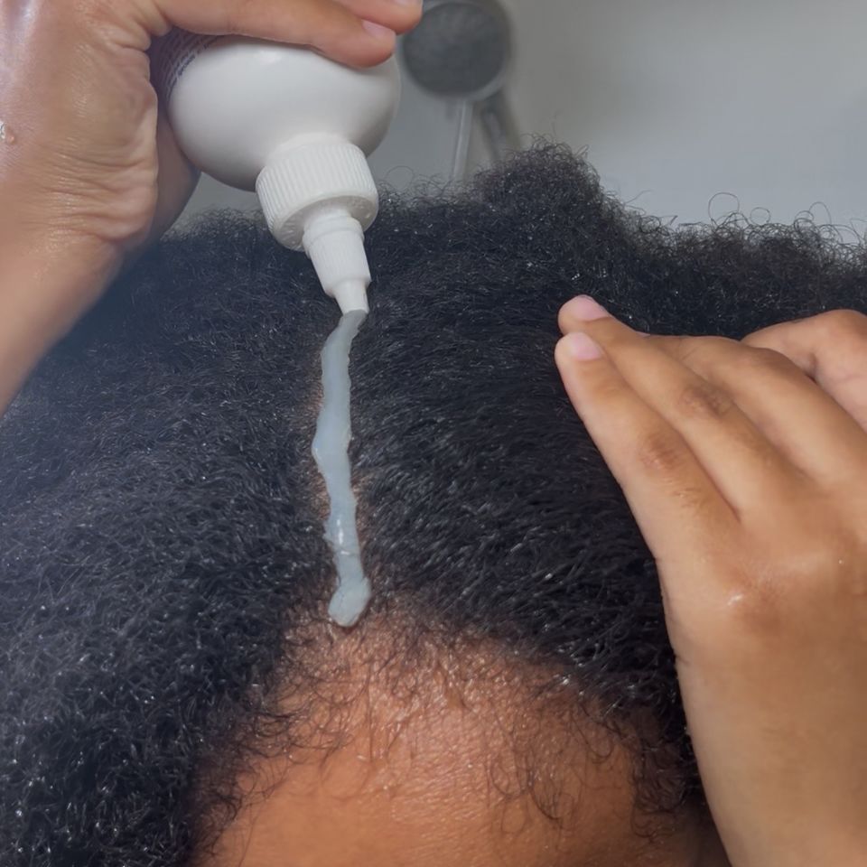 picture of a lady applying shampoo on her hair