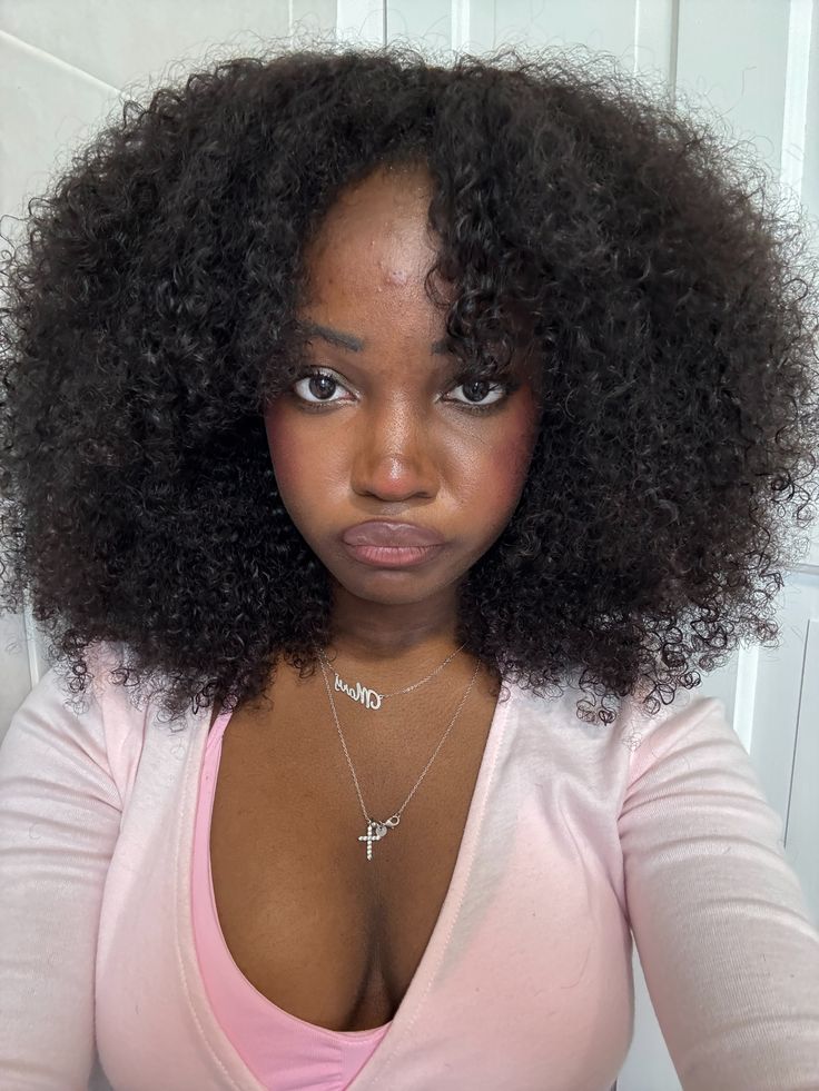 someone with natural hair with face framing curls