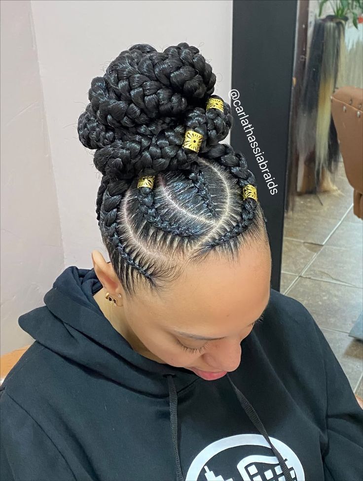 someone with cornrows updo with gold cuffs