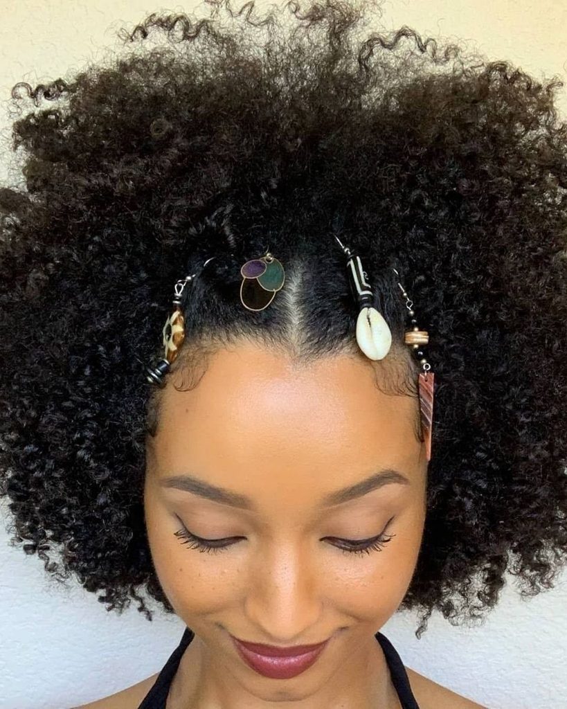 someone with natural afro with gold accessories