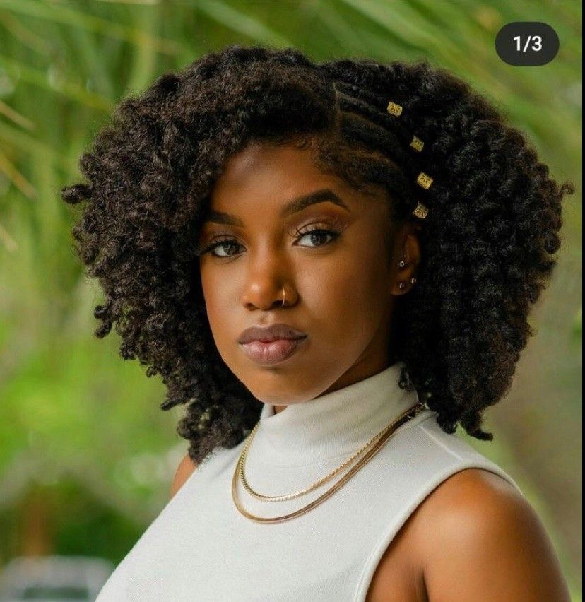 someone with twist out with gold cuffs