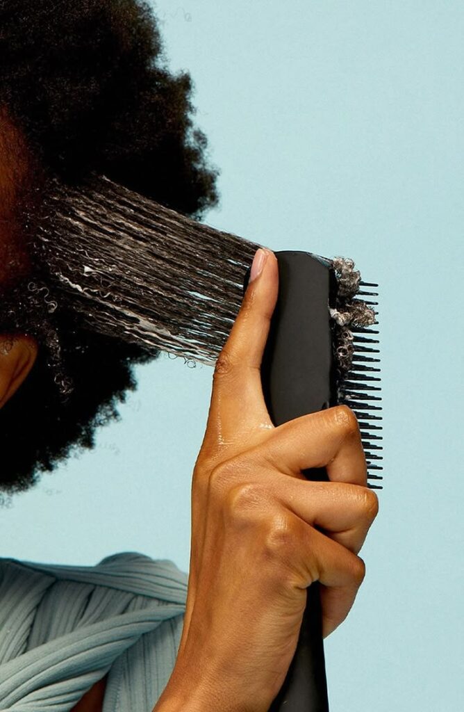 someone combing her hair with leave-in products on it