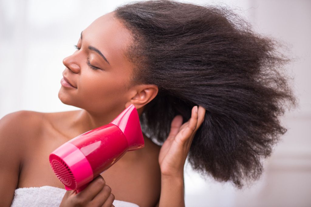 someone blow drying her hair