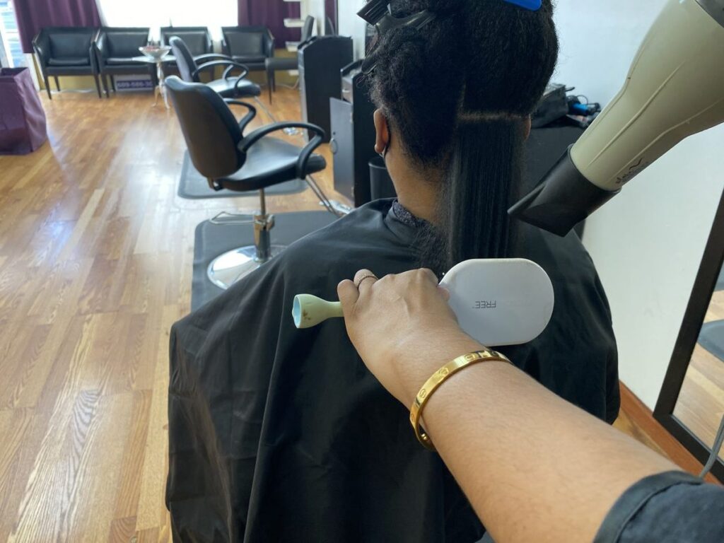 someone that is blow drying her afro hair without damage