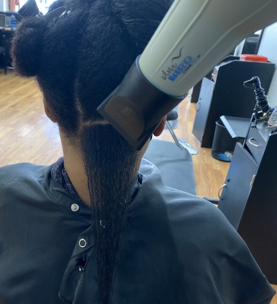 someone that is getting her hair blow dried section by section