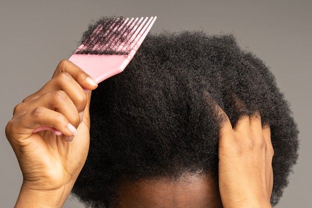 someone combing her dry hair on her wash day